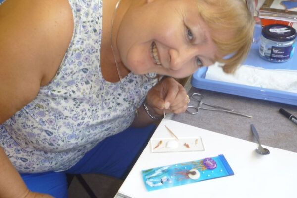a student having a good time making fused glass on a glass fusing day course