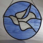 A circular traditional stained glass leaded light of a dove in flight. Learn to make a stained glass panel on our course!