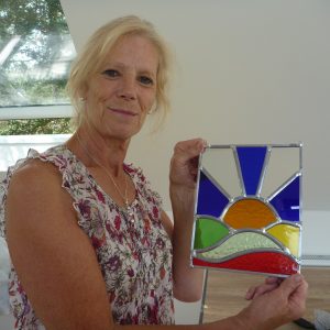 A happy customer shows off the stained glass panel that she's made on our 2 day creative glass course in Kent
