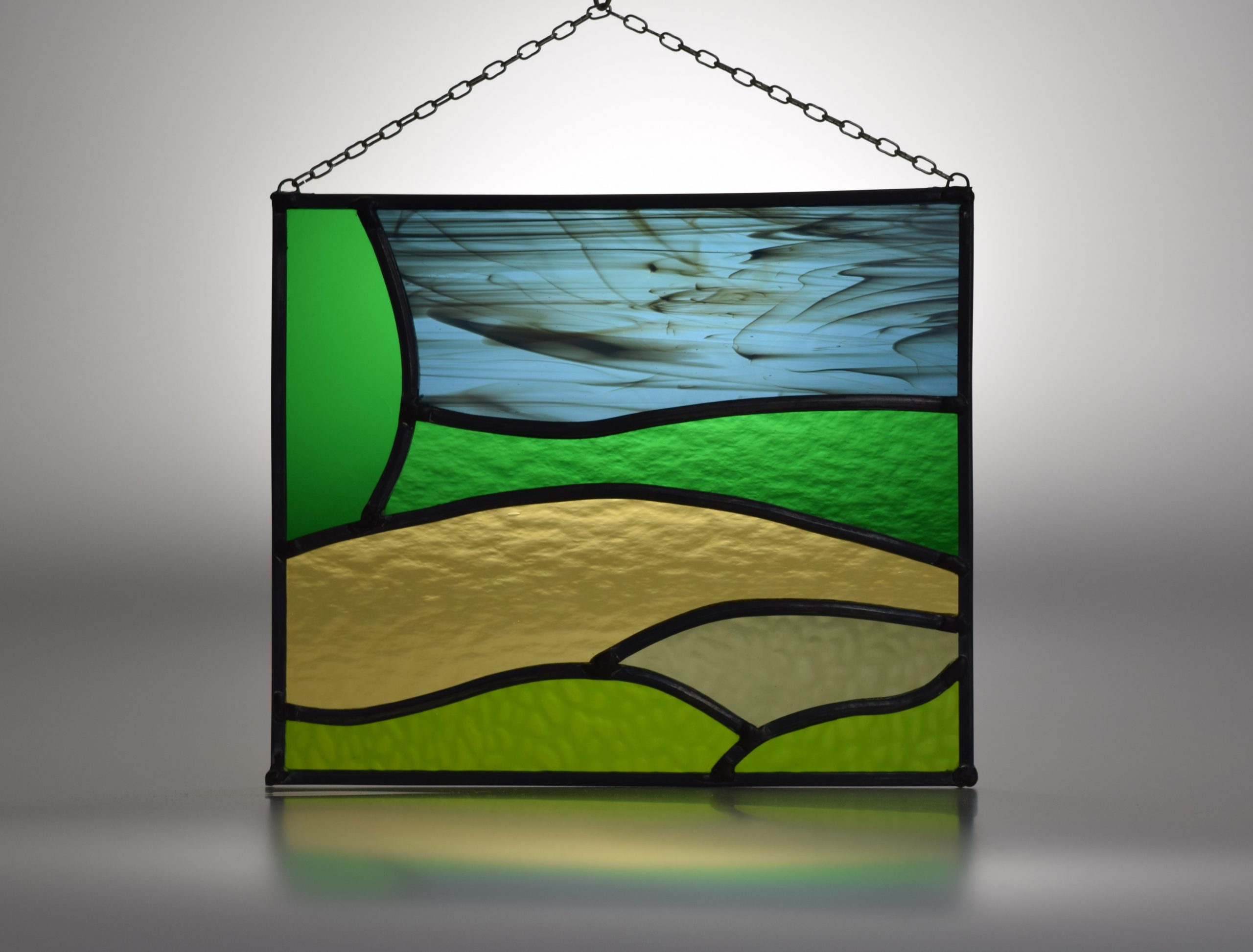 A simple stained glass panel (leaded light) showing the Kent Downs landscape