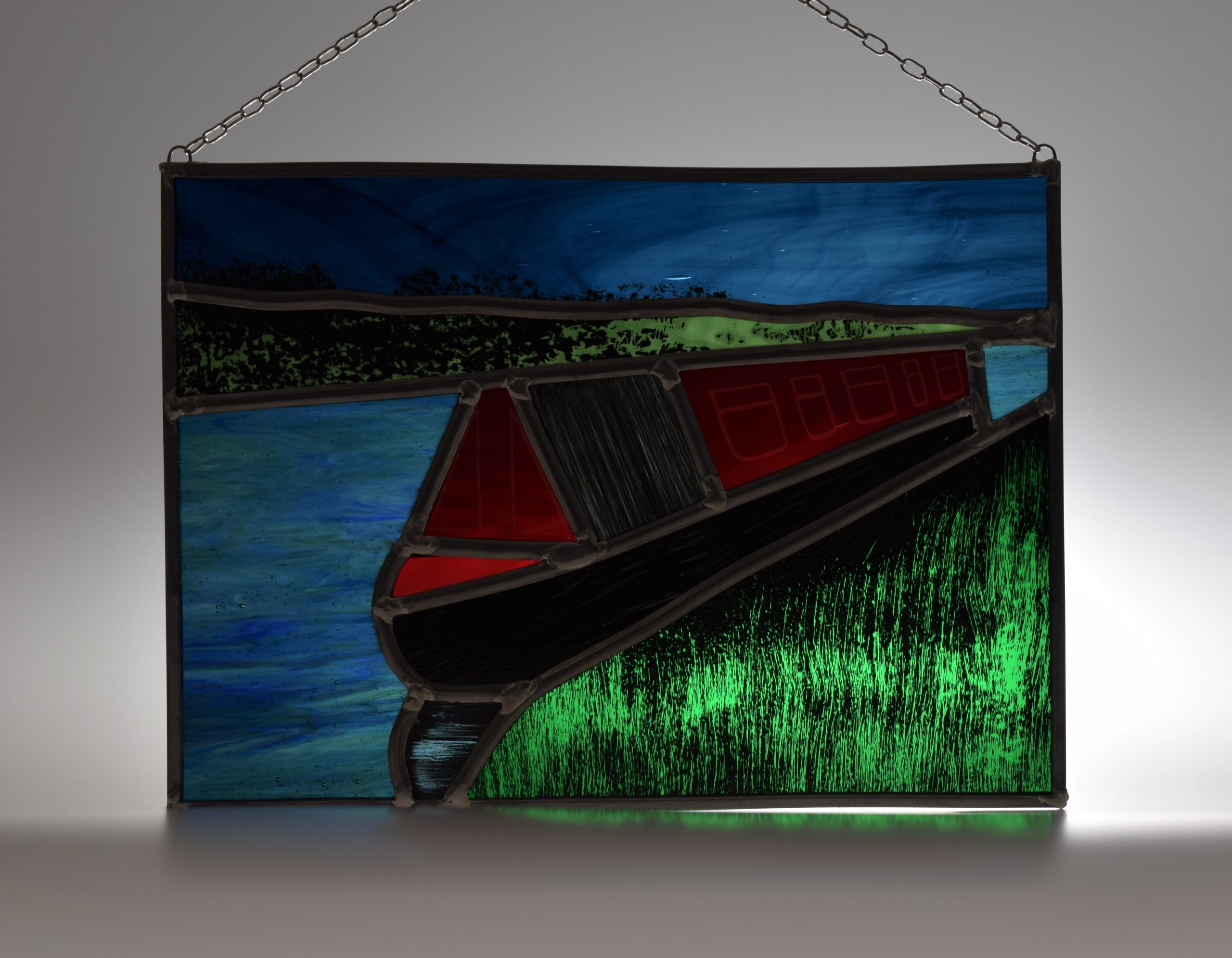 stained glass picture showing a canal boat moored on the river after a great day's boating