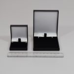 Hinged jewellery boxes that fit Royal Mail large letter classification. Black leather-effect finish on the outside and white satin inside the lid, with black velour pad inside.