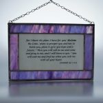Stained glass panel in lilac and white, with old testament text from the book of Jeremiah